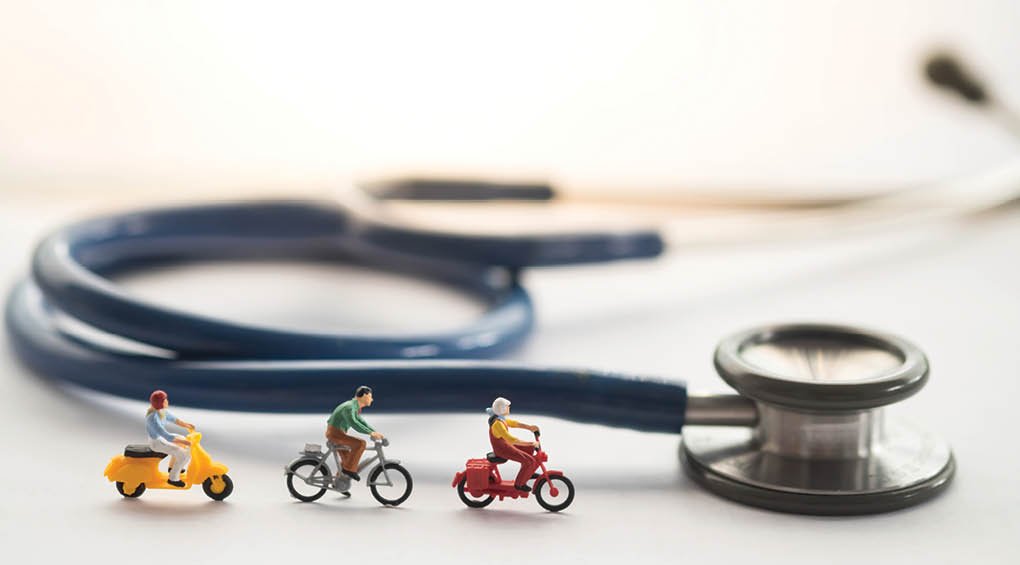 Health and travel insurance, miniature people on riding and stethoscope  Business, health care, and traveling concept 