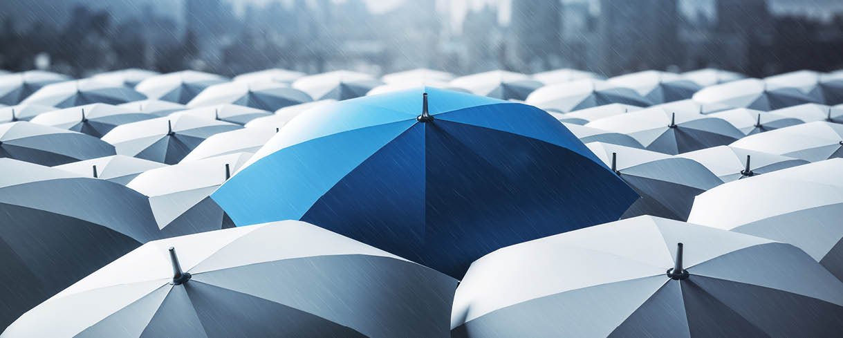 Blue umbrella on top of other gray umbrellas on city background. Business and safety concept
