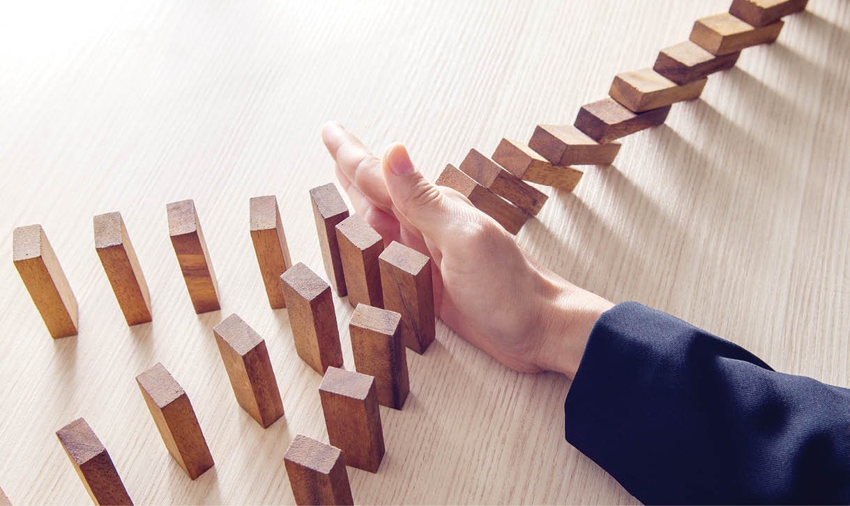 Businesswoman hand stopping the domino wooden effect concept for business.